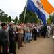 Supporters, hold a former South African apartheid government flag as slain white supremacist leader Eugene Terreblanche, coffin arrives at the church in Ventersdorp, South Africa, Friday, April 9, 2010.